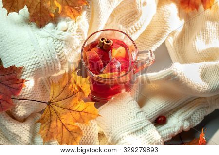 Hot grog, warm sweater and autumn leaves