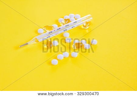 Glass Mercury Thermometer, White Pills And Capsules On Yellowbackground. Fever Heat, Antipyretic Tab