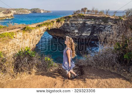 Young Woman Tourist Near Broken Beach In Nusa Penida, Indonesia Angels Billabong Beach. Popular Tour
