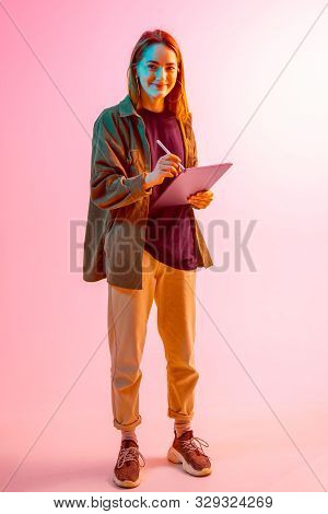 Modern Girl With Laptop, Tablet Computer. Free Creativity. A Young Blogger Makes A Home Office. Colo