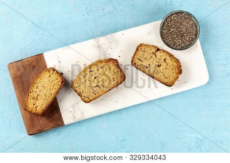 Chia Seeds Cake, Shot From The Top On A Marble Cutting Board And A Blue Background With A Place For 