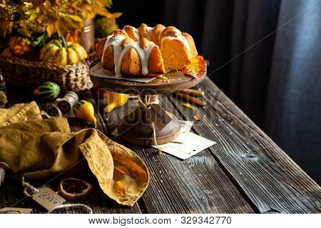 Homemade Tasty Baked Bundt Pumpkin Cake With Glaze On Top On Wooden Cake Stand On Rustic Table With 