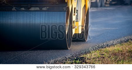 A Roller Compacting Asphalt On A Road