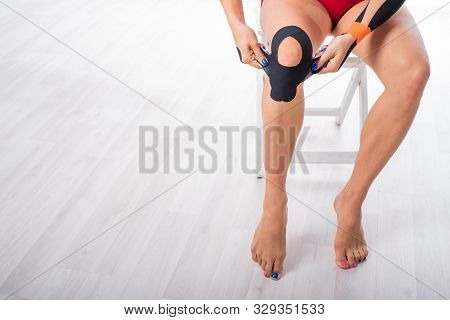 The Athlete Puts A Medical Tape On His Knee. Alternative Treatment For Joint And Tendon Injuries. Ph