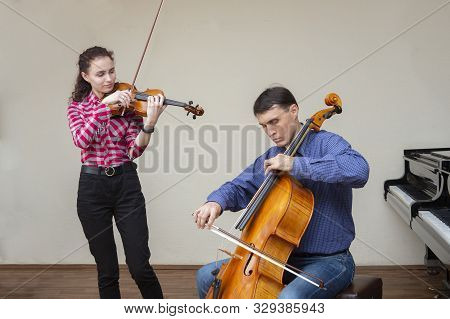 Musicians Of The Symphony Orchestra. Young Violinist And Cellist In Concert Costumes.