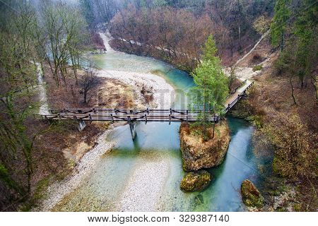 Wooden Bridge Over Mountain River In Forest In Kranj, Slovenia Near Alps During Daytime