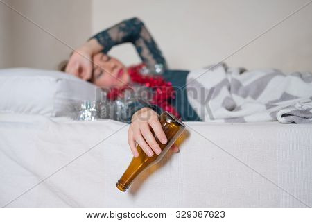 Woman In Bed Suffering From Hangover After A Loud Party. Drunk Sleeping At A Crash Pad Concept: Youn