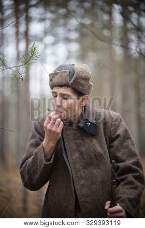A Soldier Of World War Ii Is Pulling On A Self-roll In The Forest