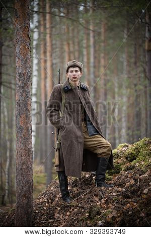 A Soldier Of World War Ii Is Standing And Looking At The Camera