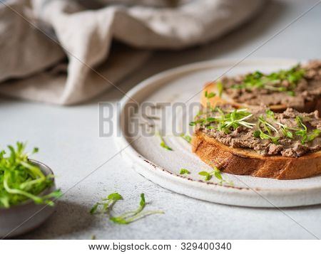 Two Toasts Chicken Rillettes (pate) On White Bread With Sprouts On White Plate On A Light Background