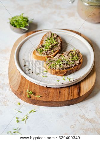 Two Toasts Chicken Rillettes (pate) On White Bread With Sprouts On White Plate On Wood Cutting Board