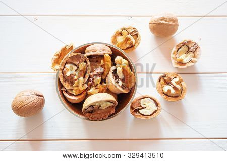 Cleaved And Whole Walnuts On A Light Wooden Background. The Concept Of Healthy Organic Food. Place F