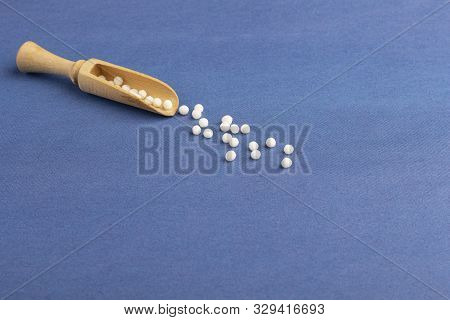 Homeopathic Globules (pills) On Blue Background. The Concept Of Healthcare And Alternative Herbal Me