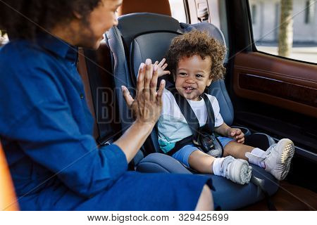 Young Mother Playing With Her Son In The Car. Two People Sitting On A Backseat.