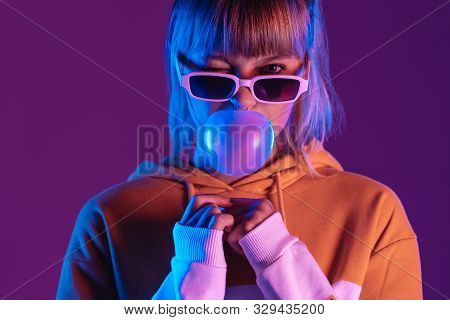 Stylish Pretty Young 20s Fashion Teen Girl Model Wear Glasses Blowing Bubble Gum Winking Looking At 