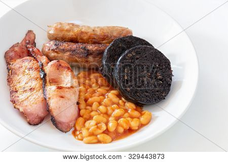 Cumberland Sausages, Back Bacon, Baked Beans And Black Pudding In A White Bowl