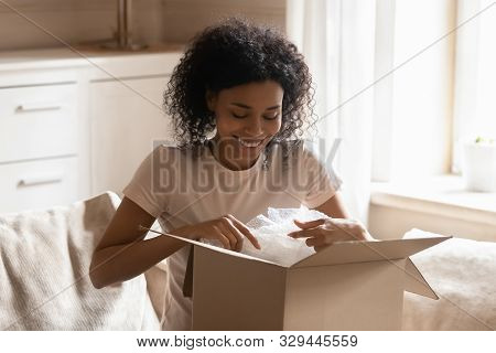 Happy African Athnicity Young Woman Unpacking Carton Parcel Online Order.