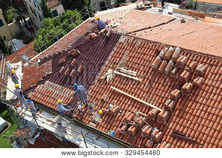 Rovinj, Croatia - October 07, 2019: Roofers On The Roof Of The Building Are Laying New Tiles. Rovinj