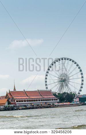 Bangkok City, Thailand - March 17, 2019: Chao Phraya River. Chang Ferris Wheel And Red Roofs Of Wat 