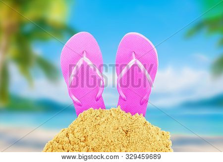 Flip-flops In The Sand Against The Beach
