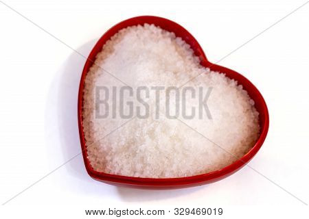 Salt Inside A Heart Shaped Container On A White Background