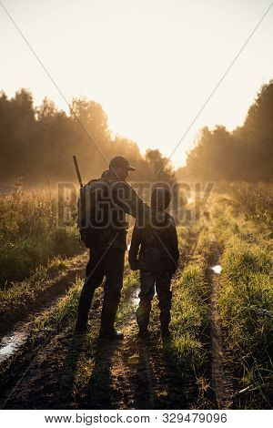 Father Pointing And Guiding Son On First Deer Hunt