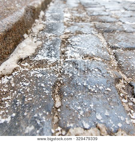 De-icing Chemicals On The Pavement. Pavement Is Sprinkled With Technical Salt Or Salt Mixtures Based