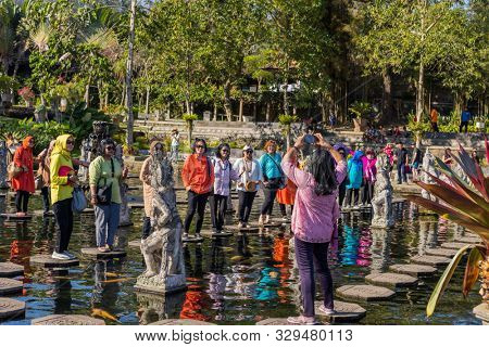 Bali, Indonesia - 17 September 2019: People walking on the stepstones of Tirtagangga Water Palace in Bali, Indonesia
