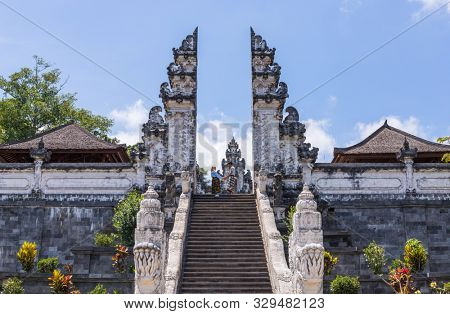 BALI, INDONESIA - SEPTEMBER 17, 2019: Couple at the entrance temple of Pura Penataran Agung Lempuyang. In Bali, Indonesia