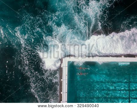 Dramatic Birds Eye View Of Ocean Waves Crashing Against Infinity Pool At Bondi Beach, Sydney Coastal