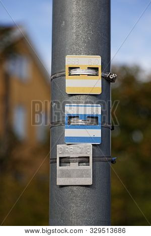 Three Metal Signs With Numbers And Letters Mounted On A Lamp Post, What Are They Good For
