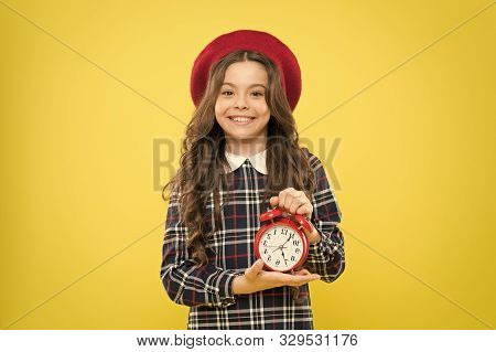Clock Is Ticking. Small Child Smiling With Mechanical Clock On Yellow Background. Adorable Kid With 