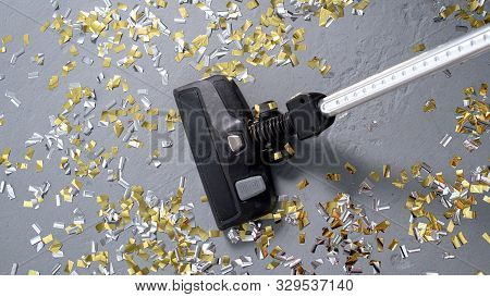 Vacuum Cleaner Cleans Up Bright Confetti. The Party Is Over. House Cleaning. Close-up. Top View.