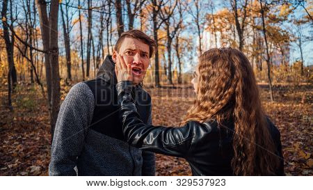A Womans Hand Hits A Mans Face In The Autumn Forest. An Emotional Male Is Getting Slapped In Face, W