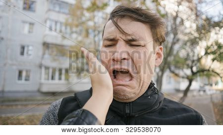 A Womans Hand Hits A Mans Face On The District Of A City. An Emotional Male Is Getting Slapped In Fa