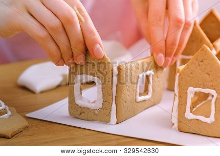 Womans Hands Make Gingerbread Houses Glues Details With Sugar Sweet Icing. Cooking Homemade Gingerbr