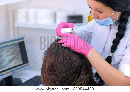 Trichologist Examines Woman Patients Hairs Using Computer Trichoscopy In Clinic. Runs A Trichoscope 