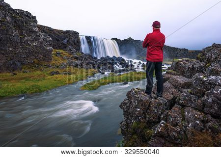 Tourist Looking At The Oxarafoss Waterfall In Iceland. This Waterfall Is Located In The Thingvellir 