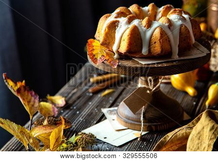 Homemade Tasty Baked Bundt Pumpkin Cake With Glaze On Top On Wooden Cake Stand On Rustic Table With 
