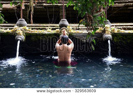 Praying In Holy Spring Water Of Sacred Pool At Pura Tirta Empul Temple, Bali