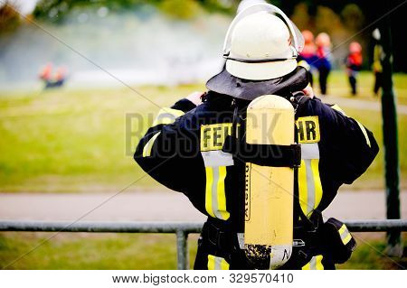 Germany, Niederstetten, Baden Wurttemberg. September 2019. Firefighter In Uniform From A Back.