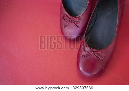Stylish Female Flat Shoes In Dark Red Color On Dark Red Background With Copyspace. Beauty And Fashio