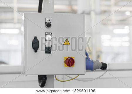 Control Unit Of Some Production Line Or Machine On A Blurred Background Of The Interior Of The Works