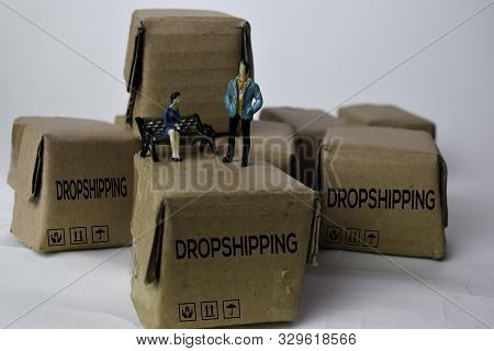Miniature Businessman Talking On Boxes With Text Dropshipping Isolated White Bakground