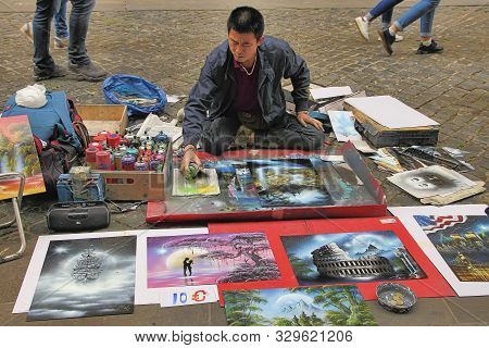 Rome, Italy - April 9, 2018 : Street Artist - Young Man Painting With Spray Pictures Of Colosseum On