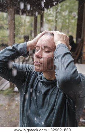 Calm, Relaxed Woman Standing In The Warm Rain. She Closed Eyes And Enjoys The Raindrops That Fall On