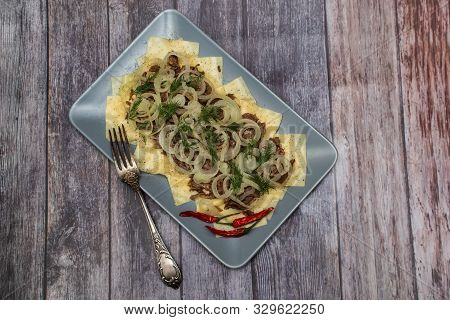 Beshbarmak Is A National Tatar Dish - Square Pasta With Boiled Meat And Onions. On A Black Backgroun