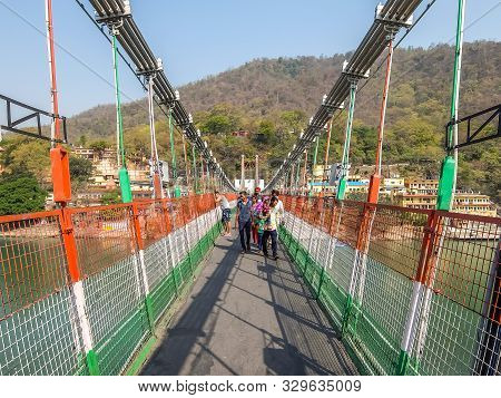 Rishikesh, India - Circa April 2018. Bridge Over Ganga River, Ram Jhula, Rishikesh. People Crossing 