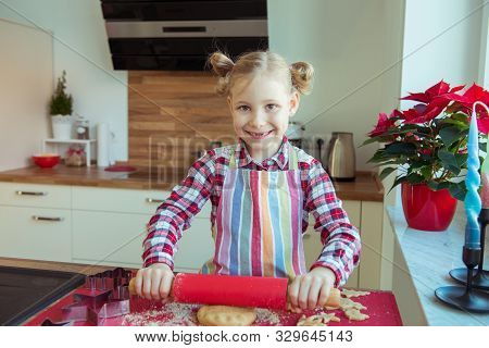 Pretty Little Girl With Funny Pigtails Decoraiting Christmas Cookies Of Different Forms In Kitchen