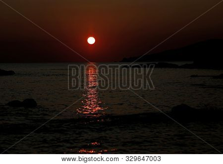 Red Sun And The Reflection On The Water Of The Sea At Evening
